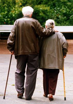 Una coppia di anziani a passeggio in un giardino in una foto d'archivio. ANSA